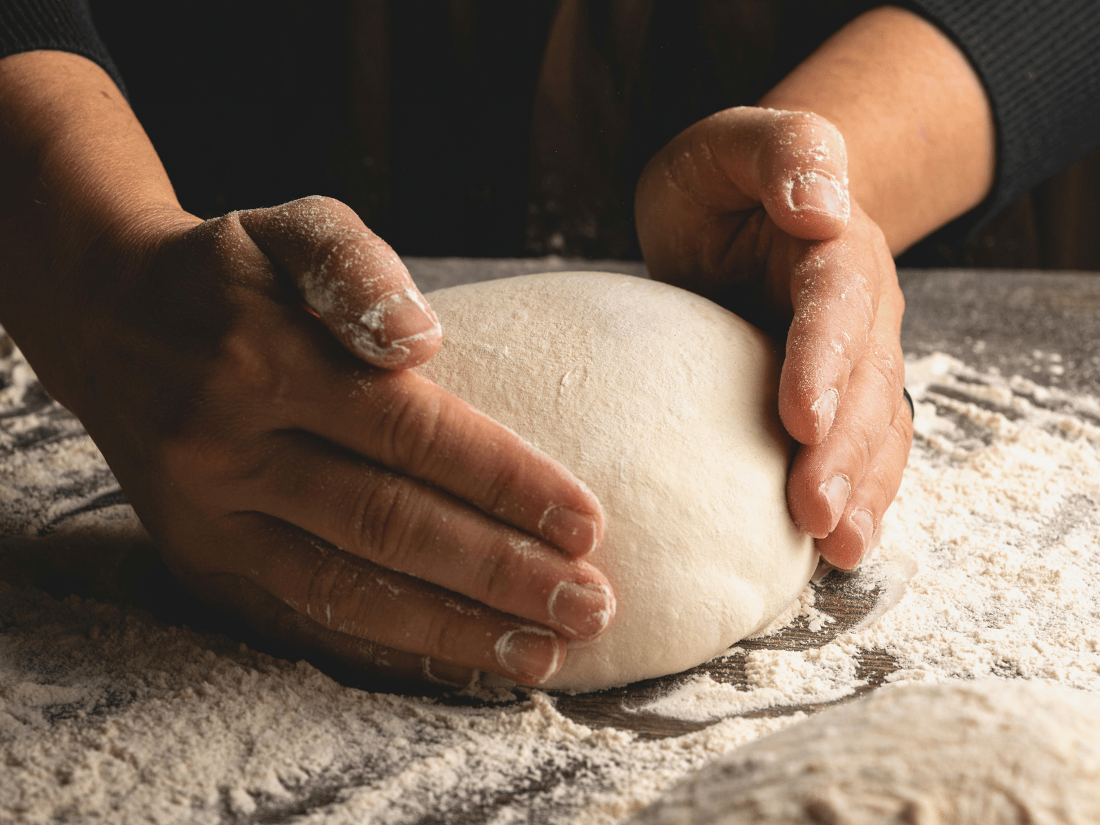 Home 8 Hands shaping a loaf of sourdough